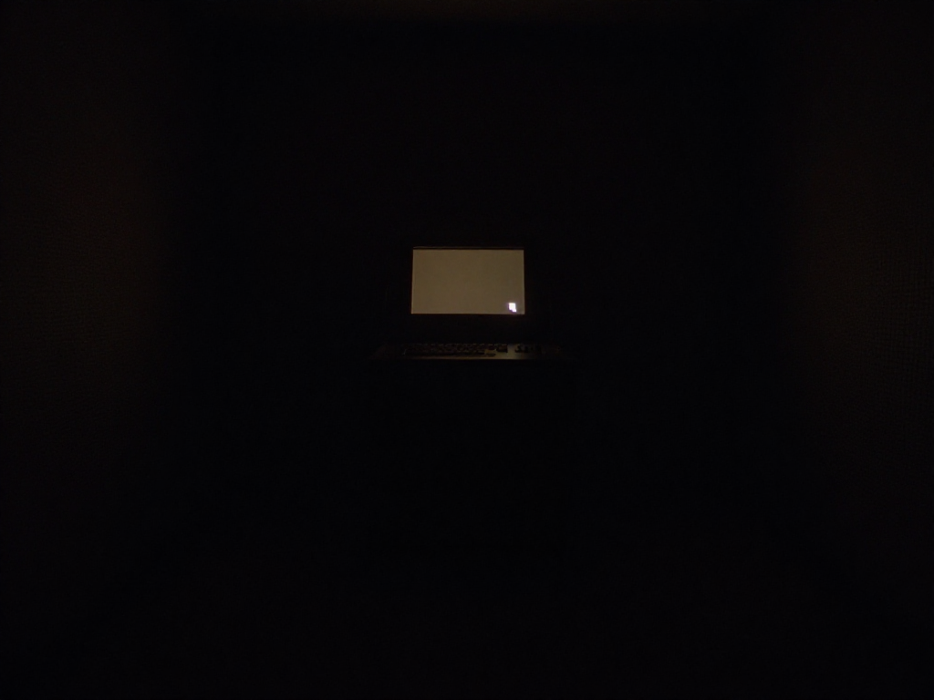 Empty dark room with a single terminal screen